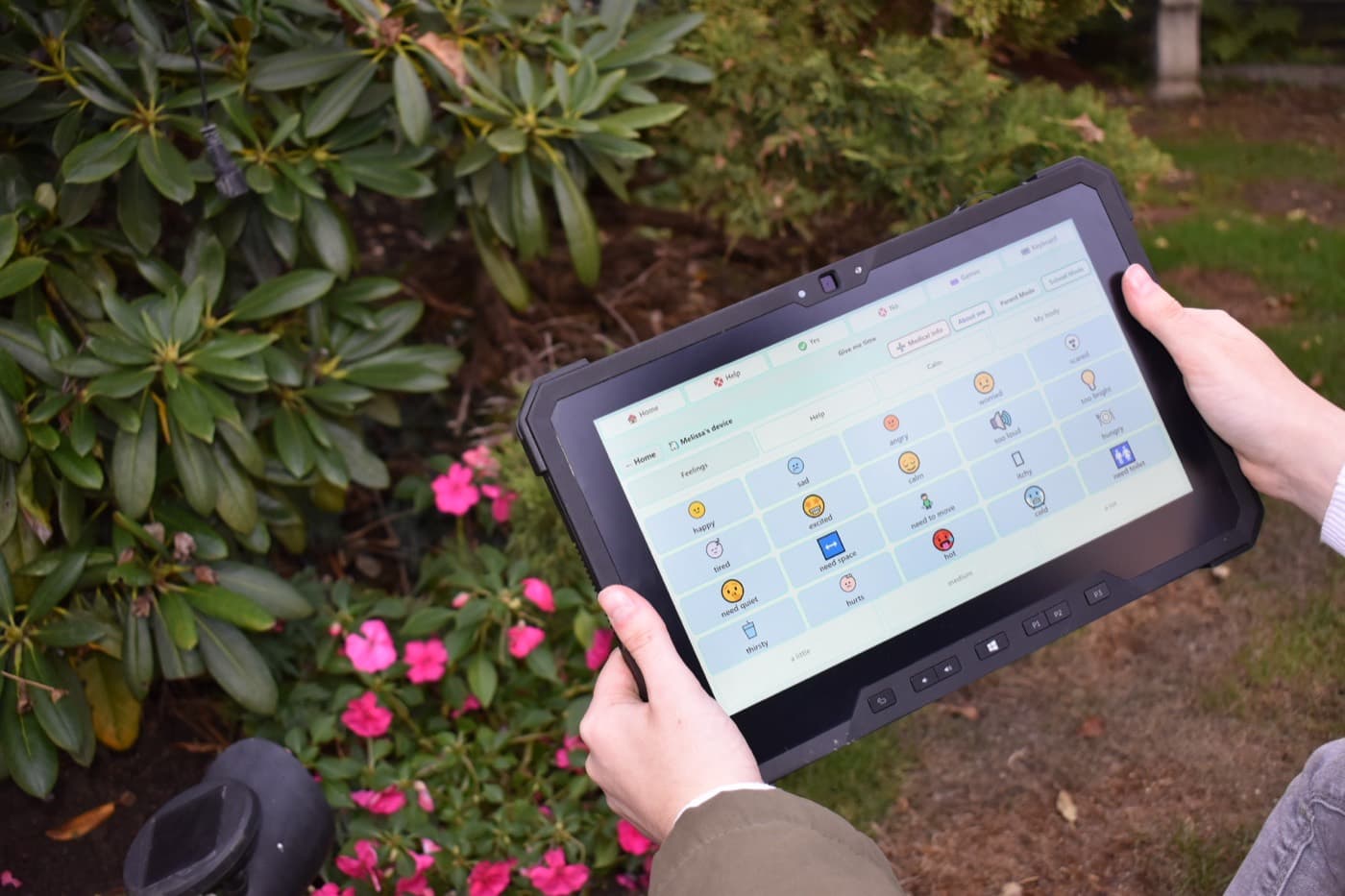 Rugged Speech's Feelings page on a rugged tablet, held in a garden
