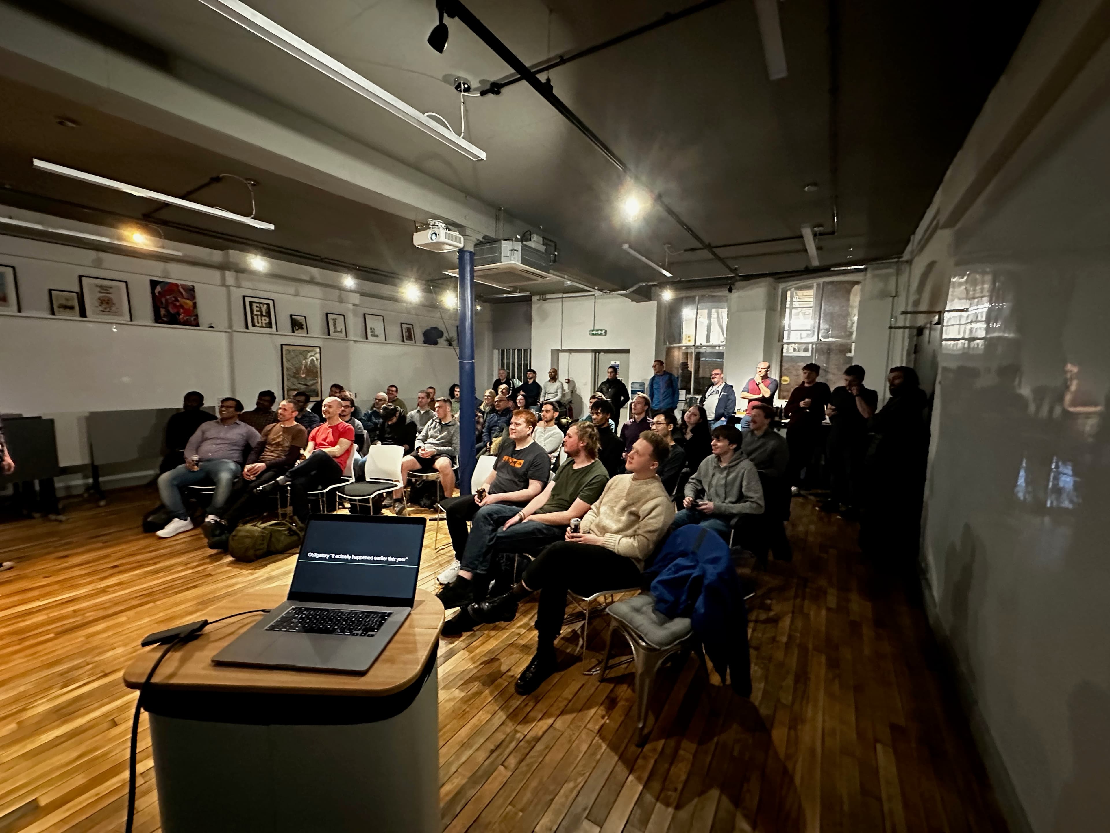 A packed evening meetup in a brick-walled venue